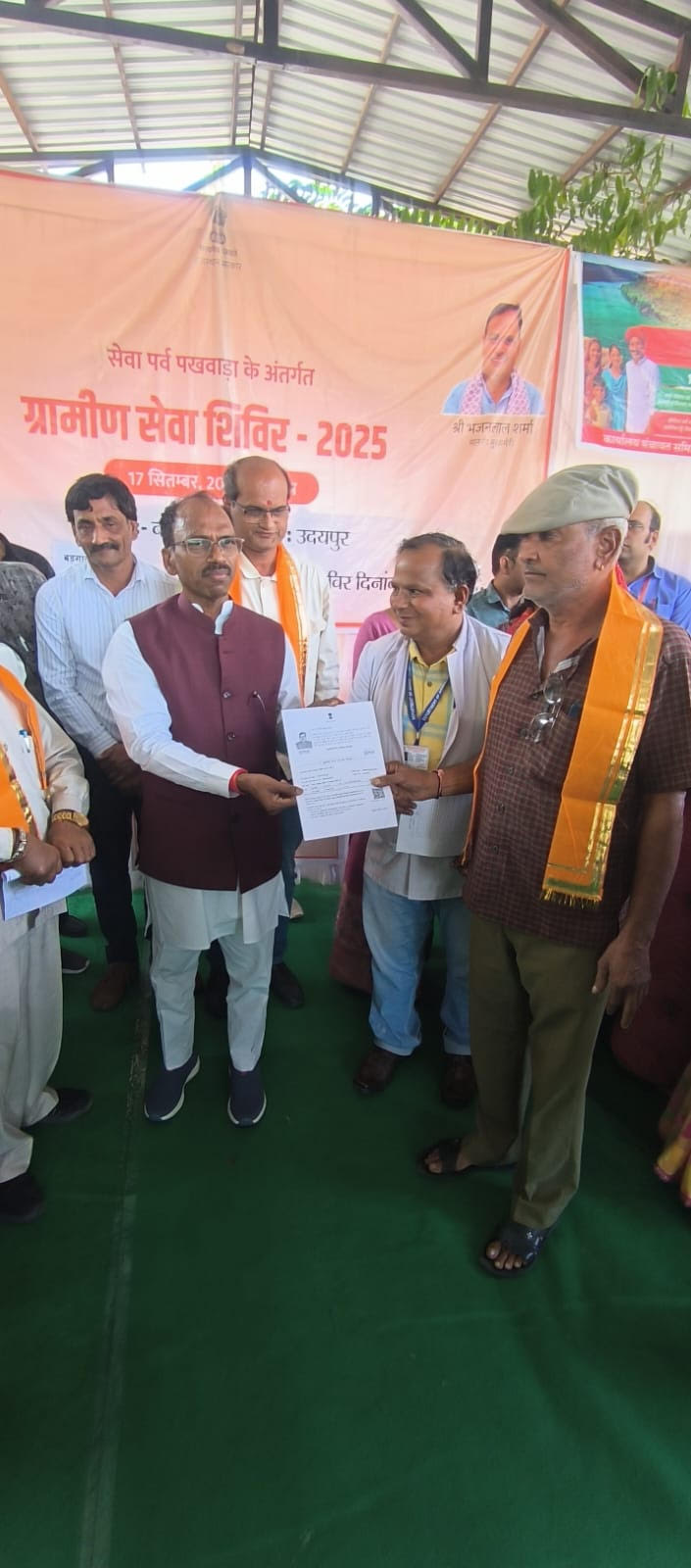 सफलता कि कहानी ग्रामीण सेवा शिविर  बड़गांव में   पाॅलिसी वितरण  करते डॉक्टर मन्नालाल रावत